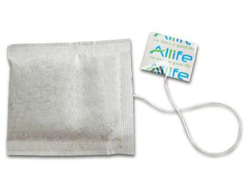3 side seal tea bag with an attached piece of string with a paper label